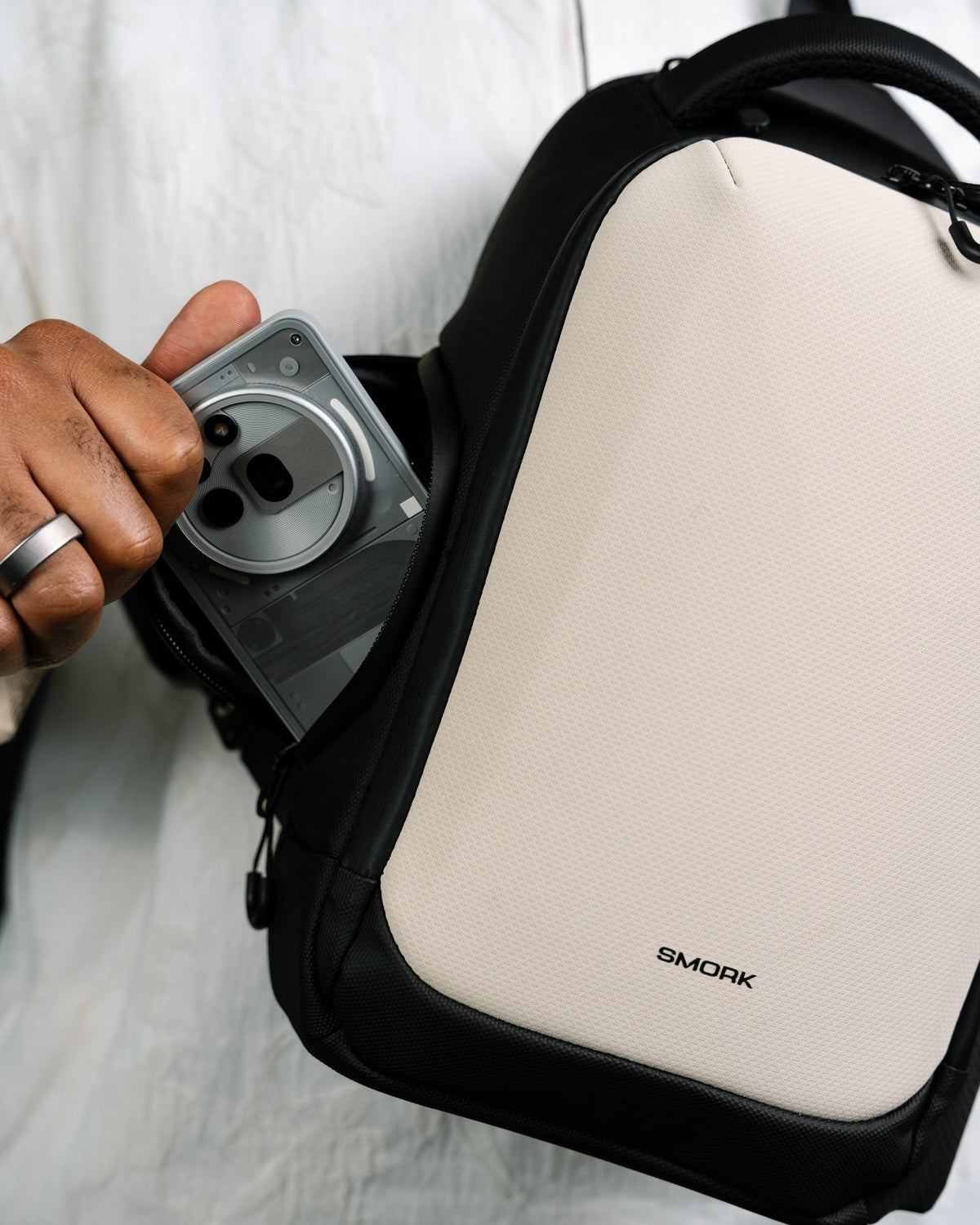 Quick-access pocket on the Smorky Sling 6L, phone being pulled out